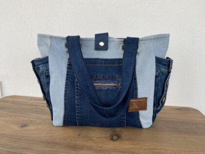 Recycled denim tote bag flatlay on white background with sturdy stitching and eco-friendly design.
