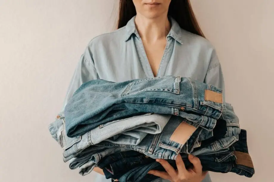 Hands preparing recycled denim fabric for a new handmade creation.